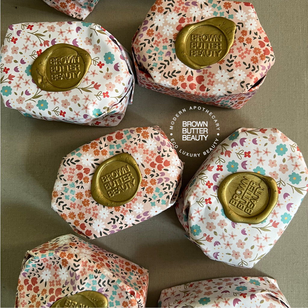 Artisan oval-shaped turmeric soap wrapped in decorative paper, cured for a long-lasting bar.